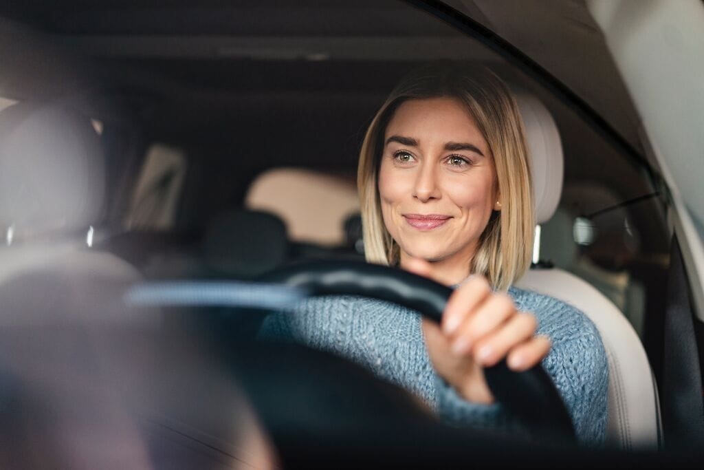Mulher sorridente a conduzir
