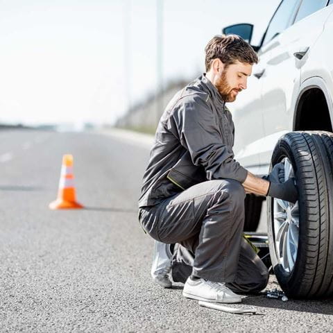 Autopanne, Mann wechselt Reifen