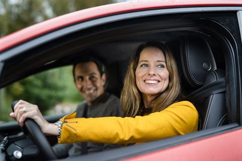 Frau lächelt aus dem Auto heraus