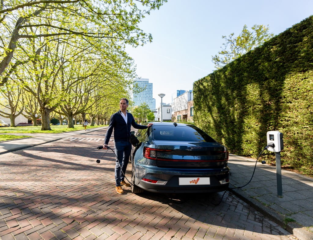 Man holding charging cable next to Polestar