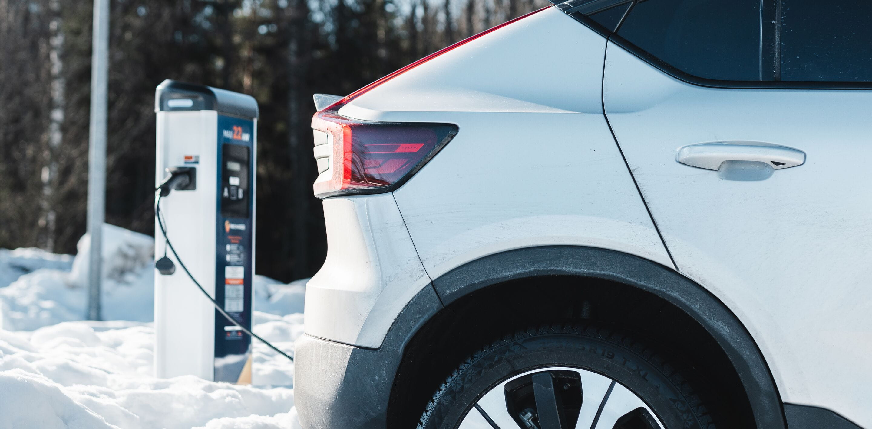 White electric car charging in snow