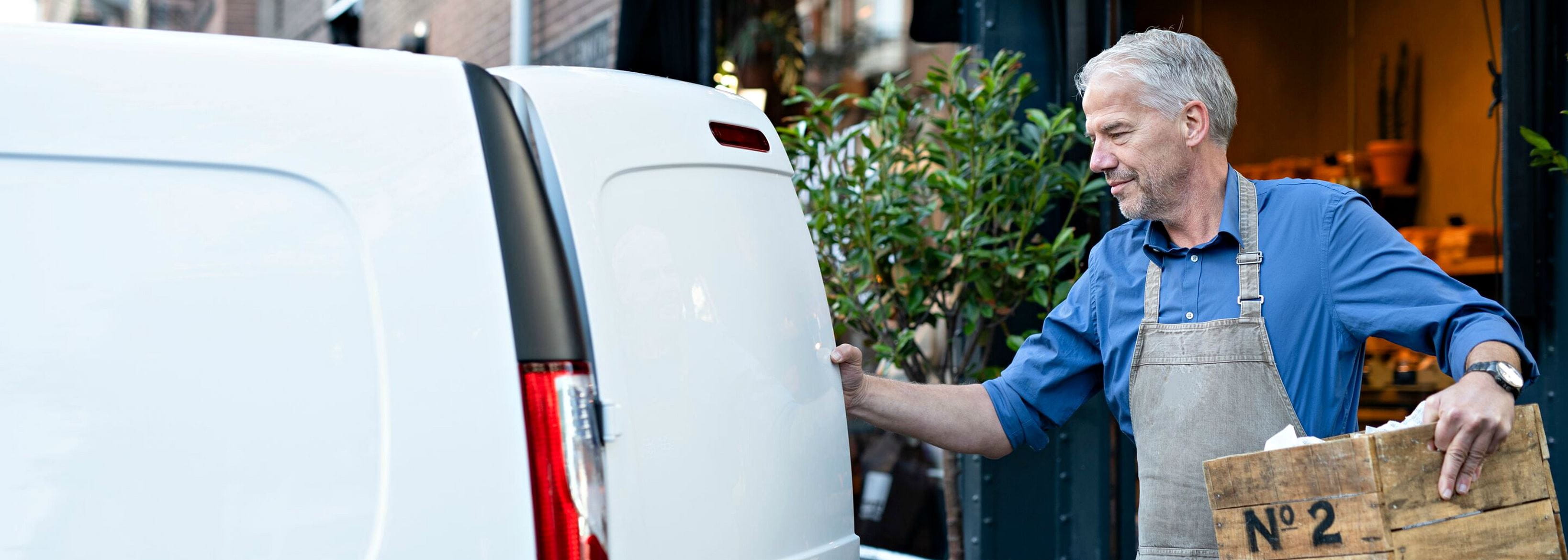 a man putting a basket in the van