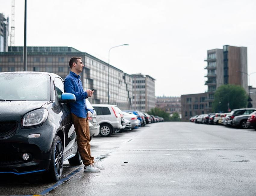 Man nex to a car-plenty of parked cars 