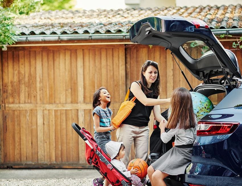 Woman with 2 children on the back of the car