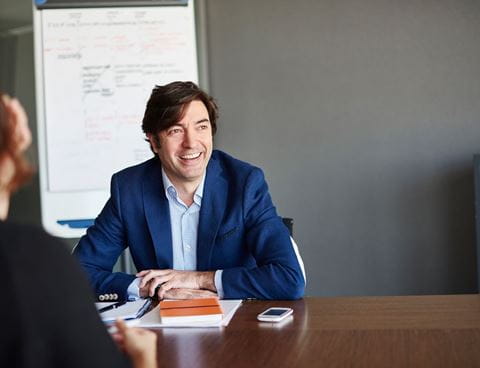 Man at desk laughing Leaseplan