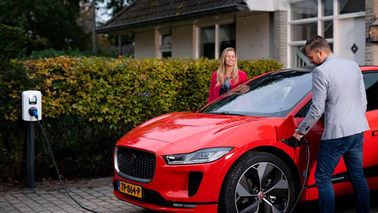 Couple charging red EV