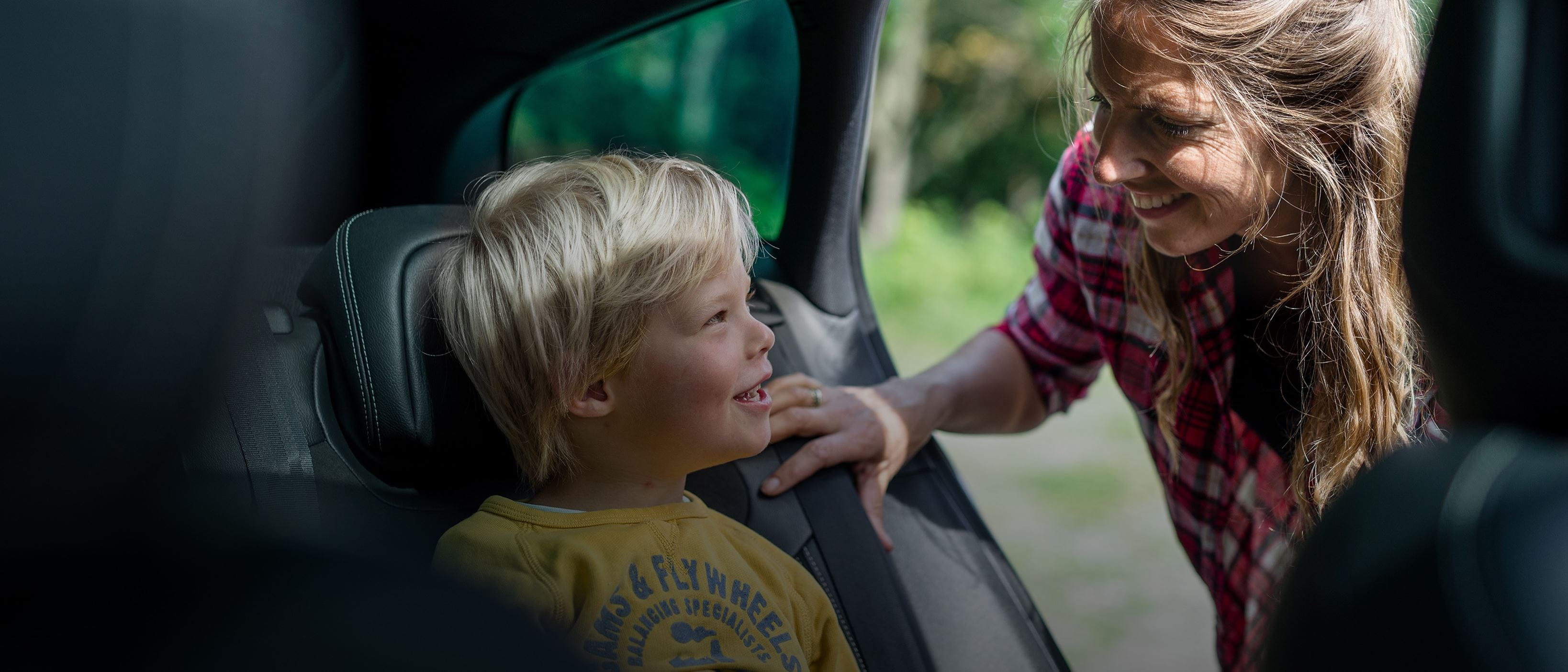 Woman checking on child in back seat