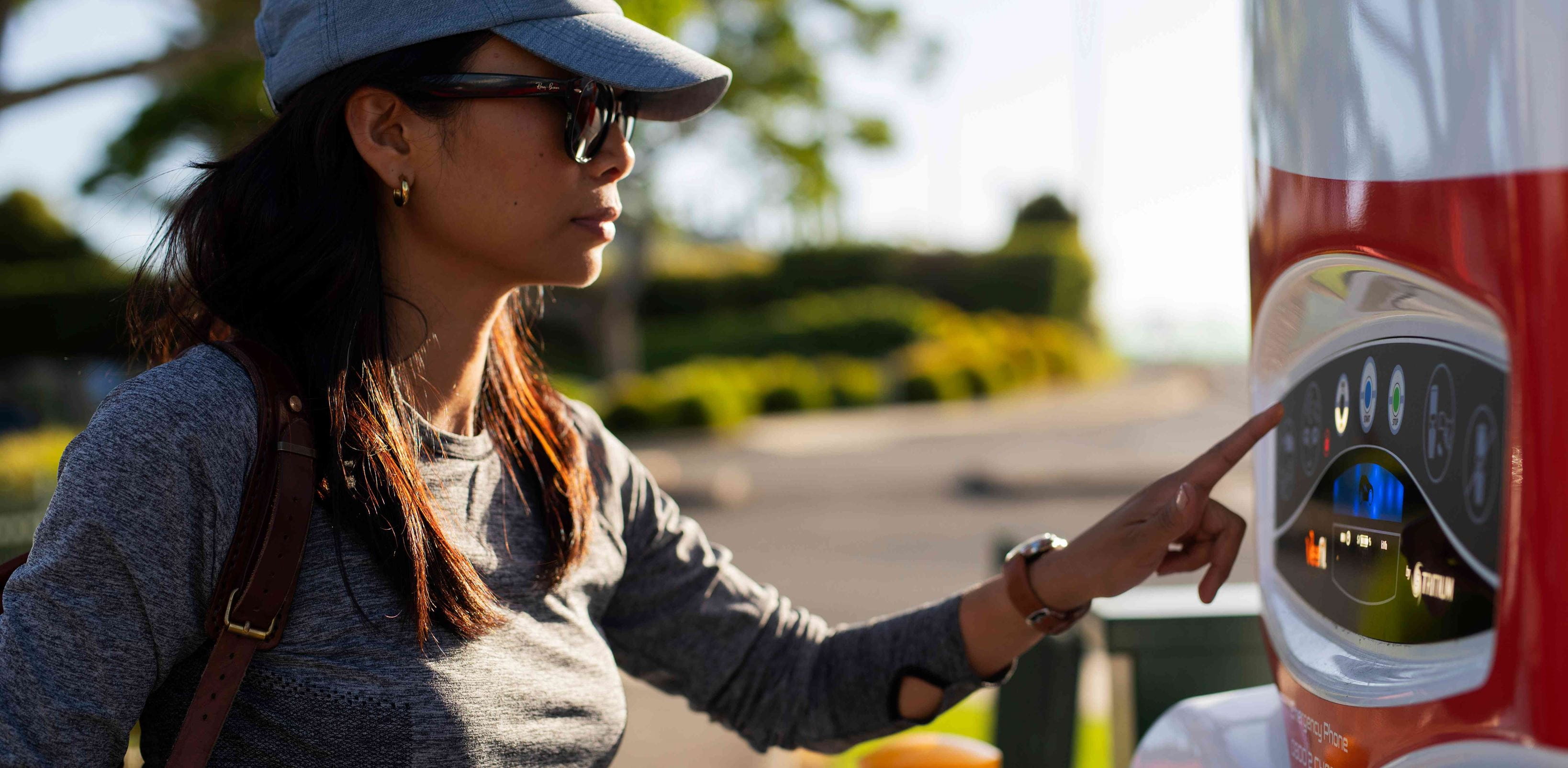 A woman using a street EV charger