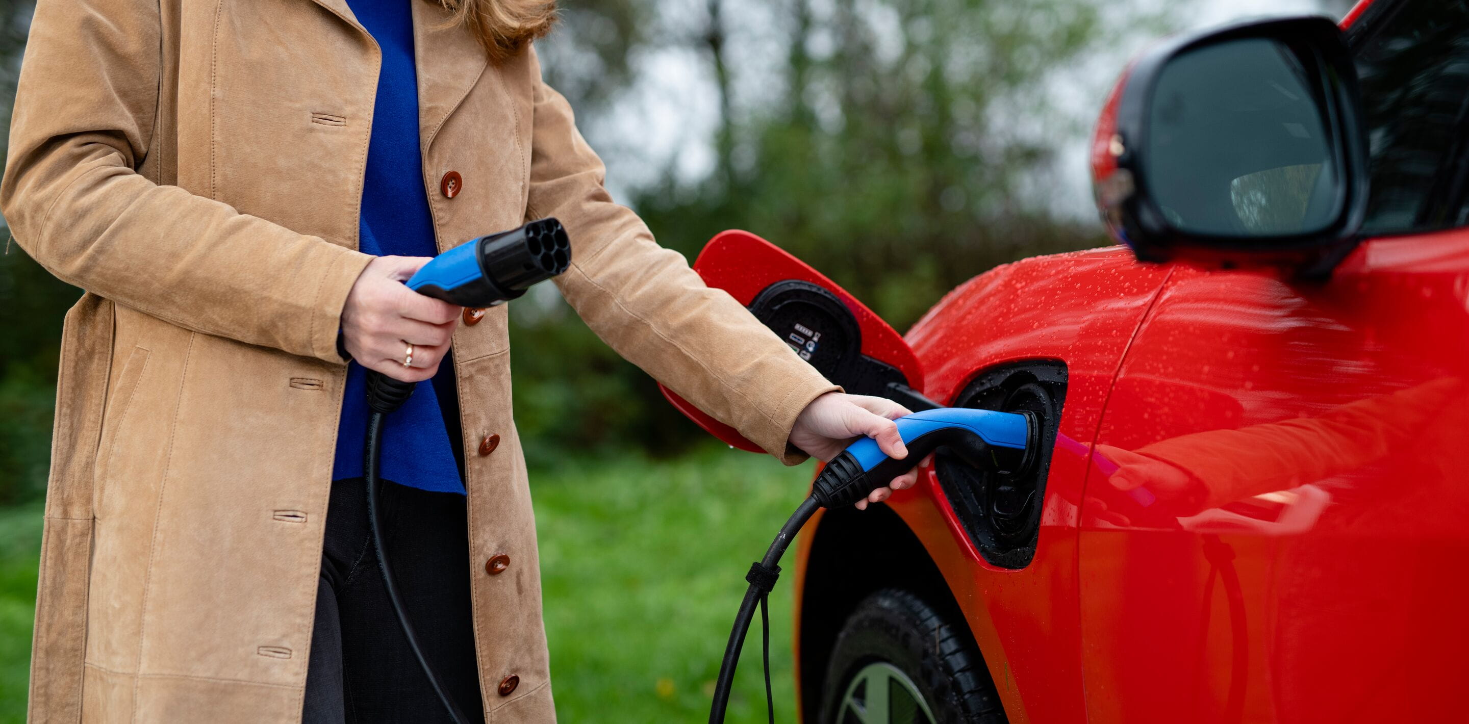 Close up - woman charging electric vehicle