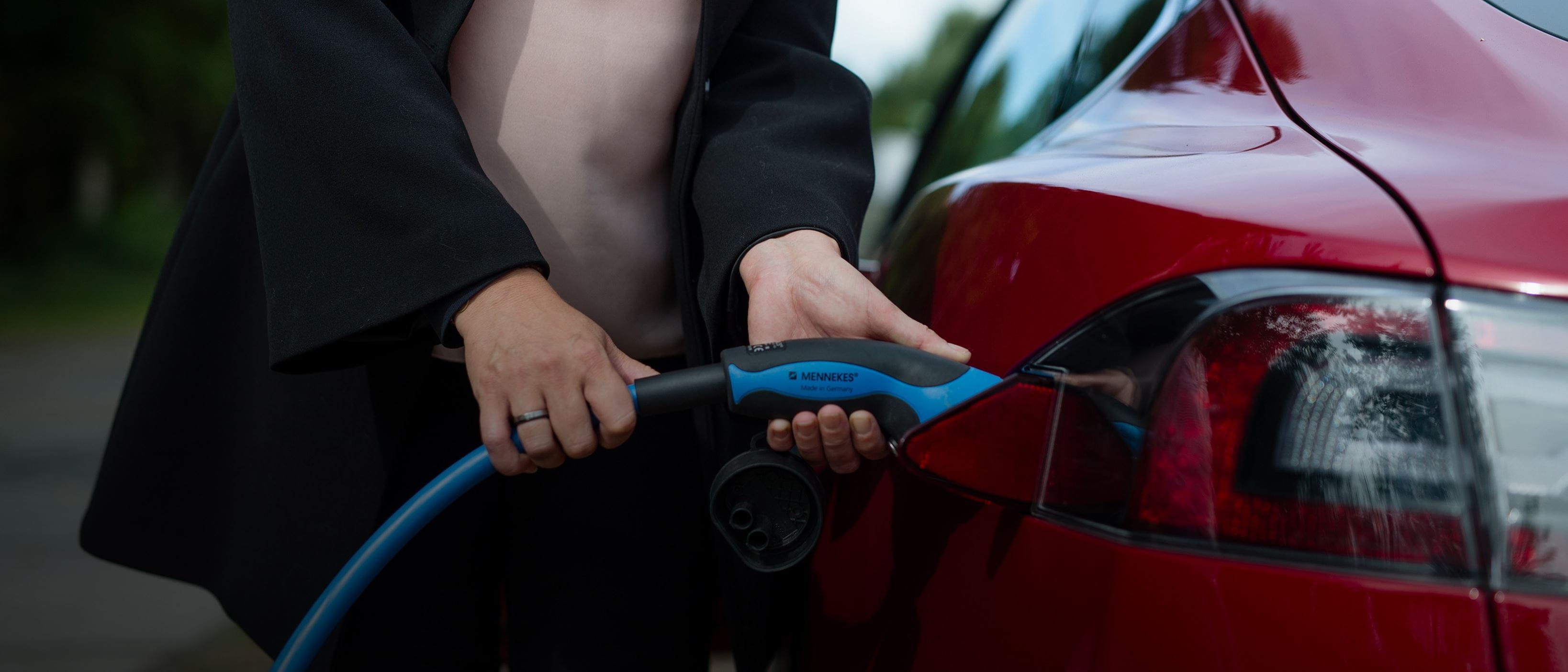 Close up - woman charging red Tesla