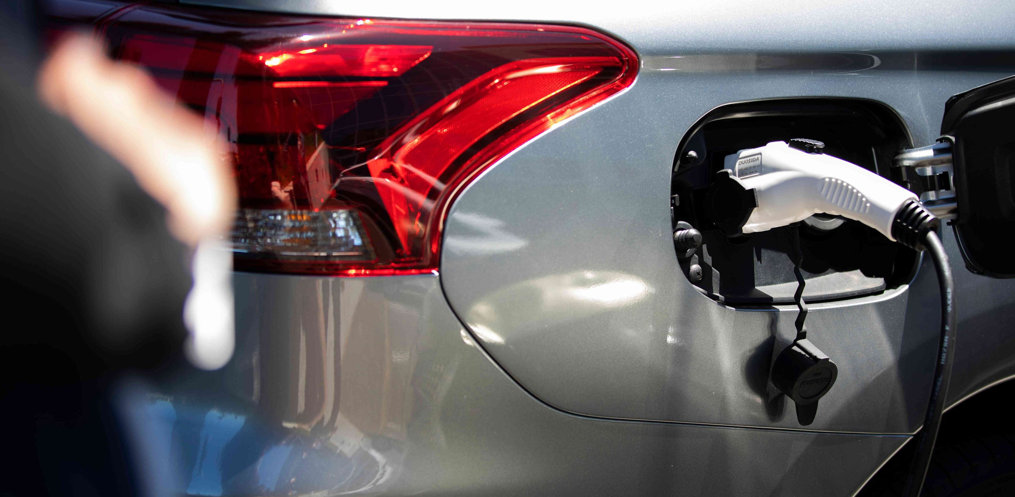 Close-up of the grey electric vehicle connected to an EV charger