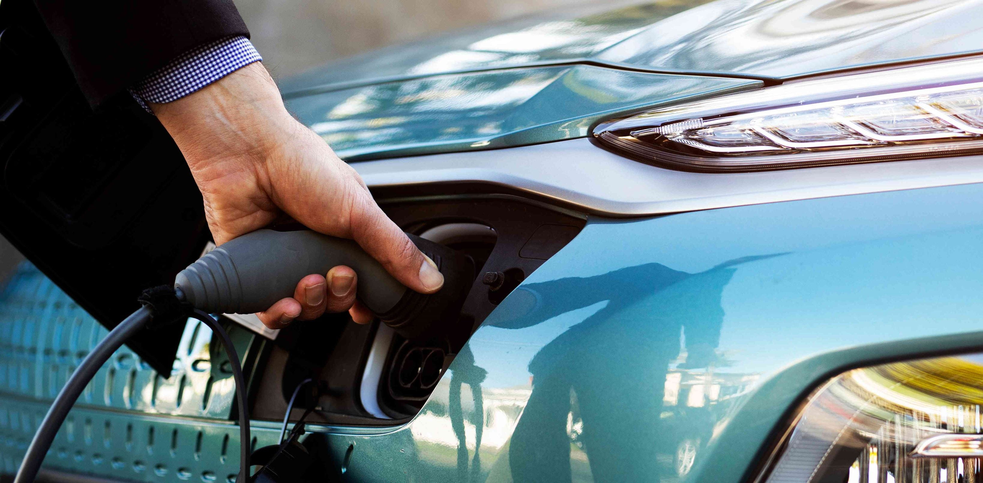 Close-up of male hand charging an electric vehicle