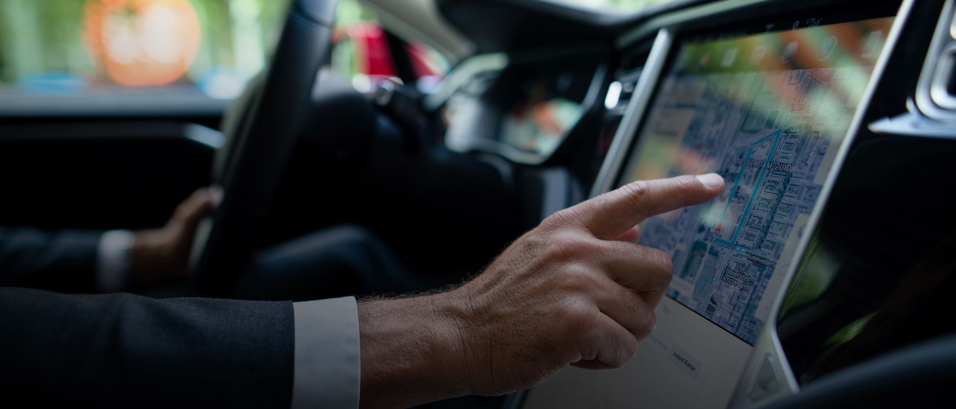 a male hand touching a screen in a car