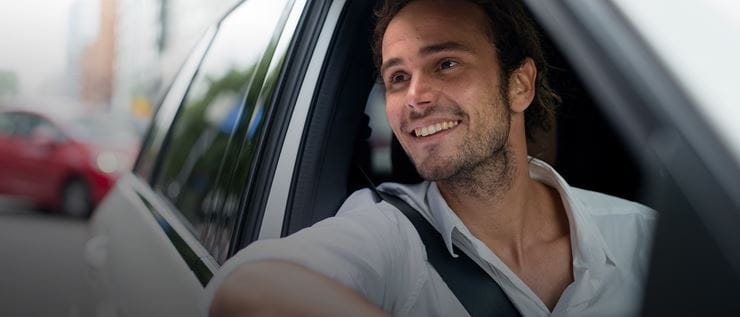 Hombre sonriendo dentro de un coche 