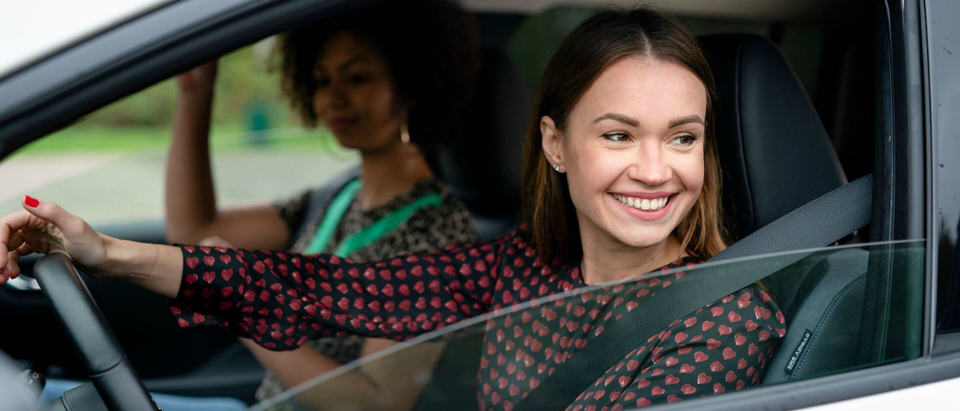 Two young women in car driving