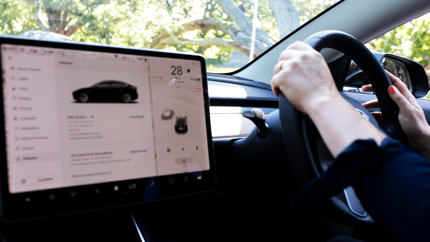 woman driving a tesla with screen on