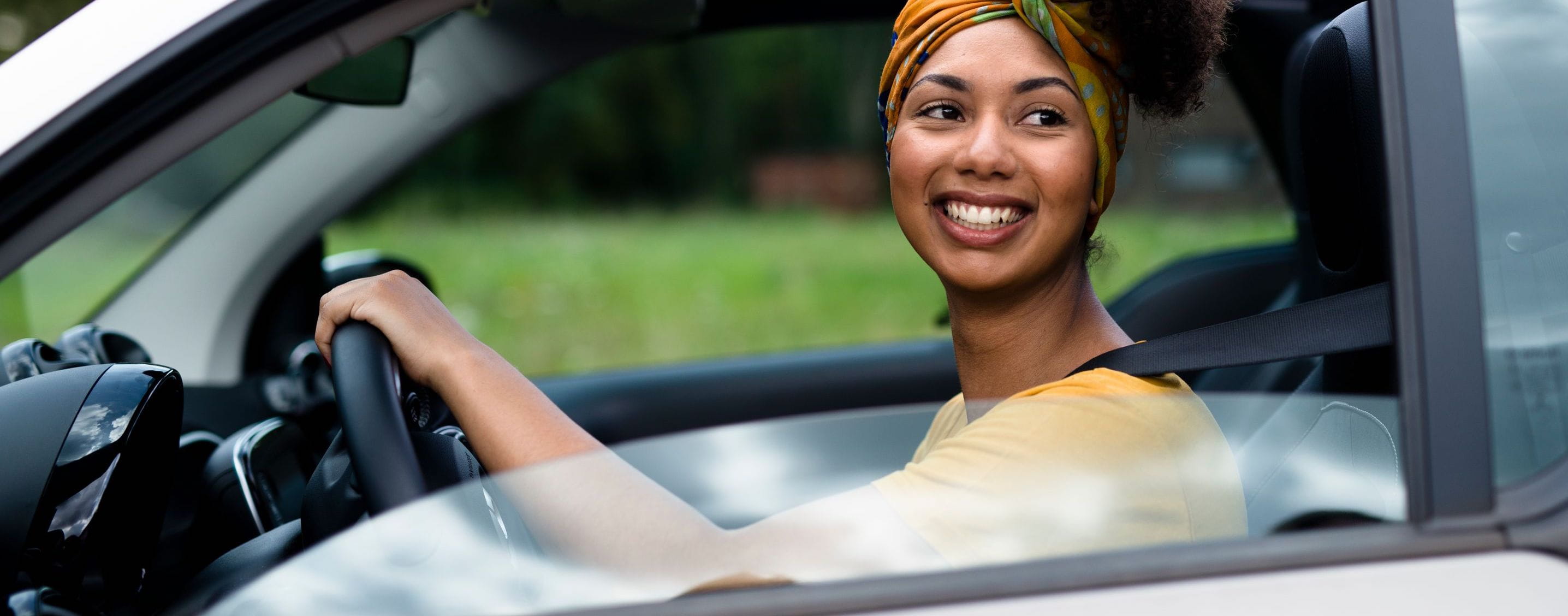 Woman smiling and driving cropped