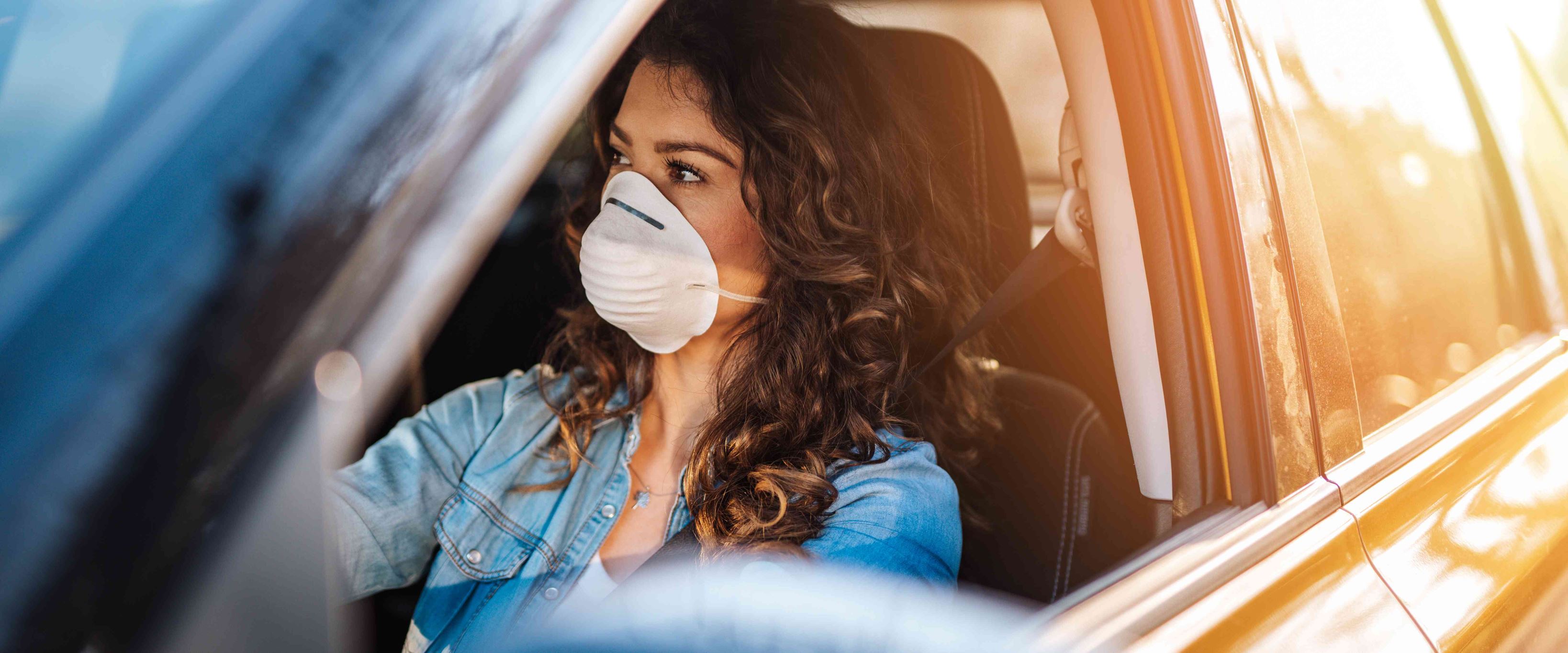 Woman wearing face mask driving
