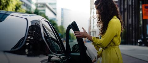 Close up - woman in yellow dress getting into car