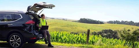 Man in high vis sitting in boot looking at field