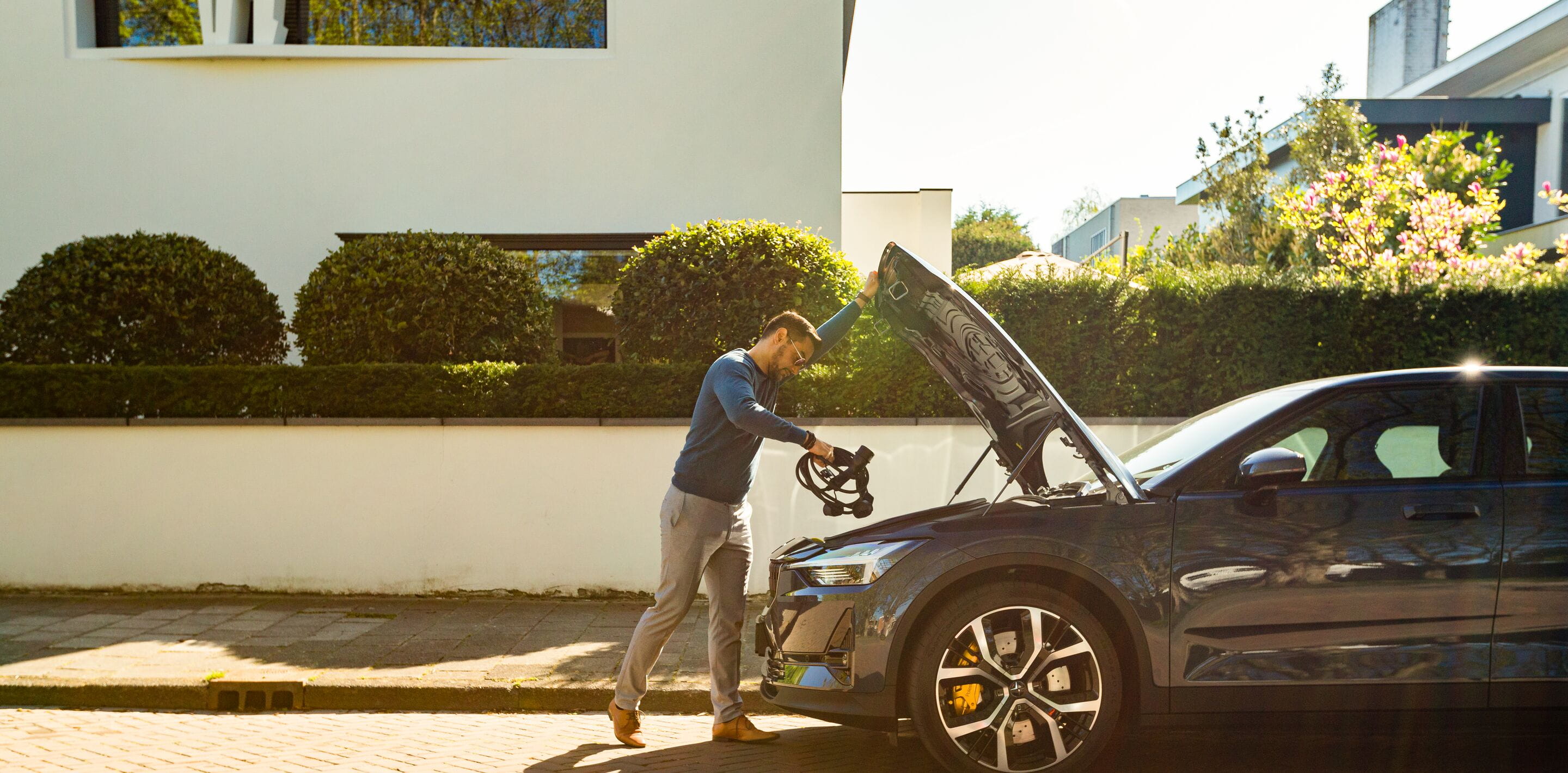 Man putting charger cord in Polestar 2