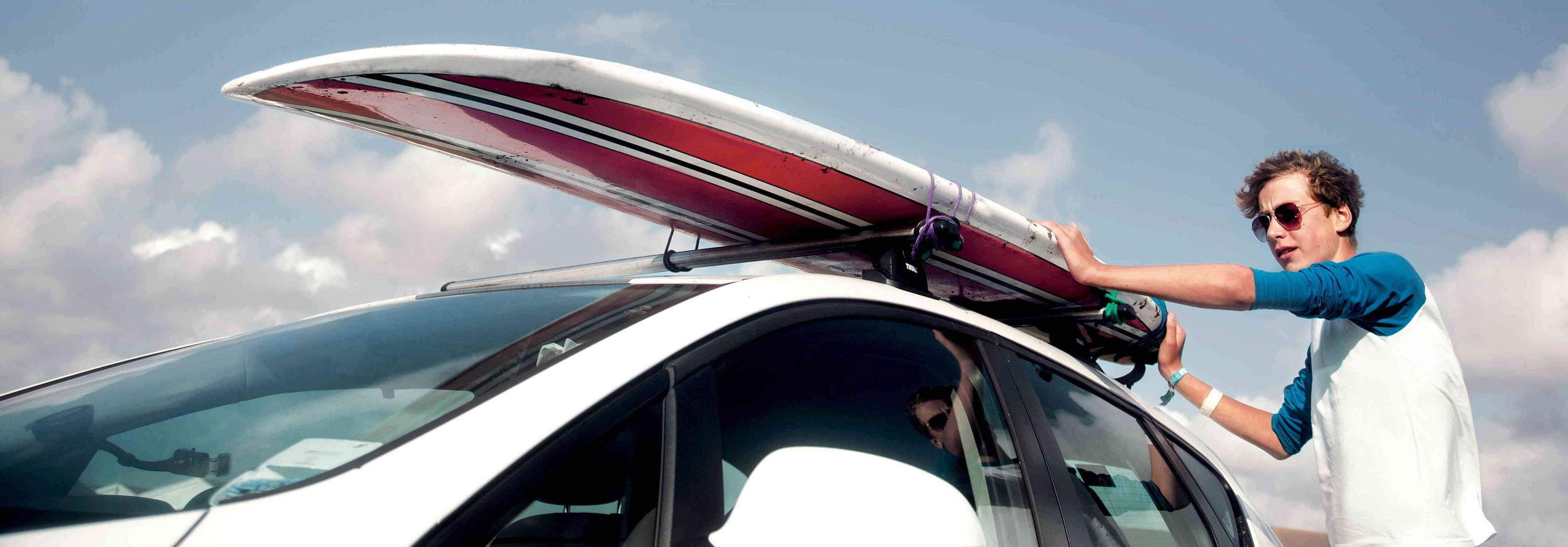 Surfboard attached to roof racks for summer holidays