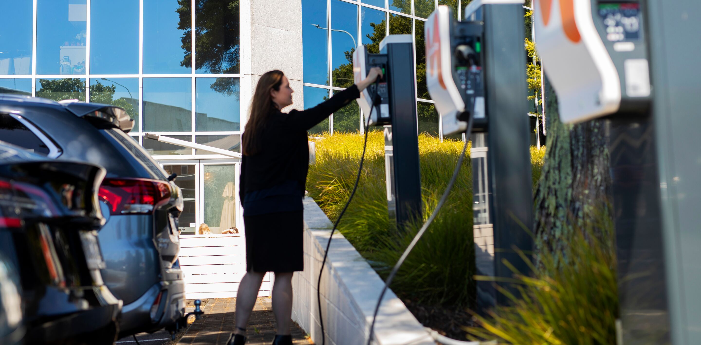 woman picking up plug from charging station